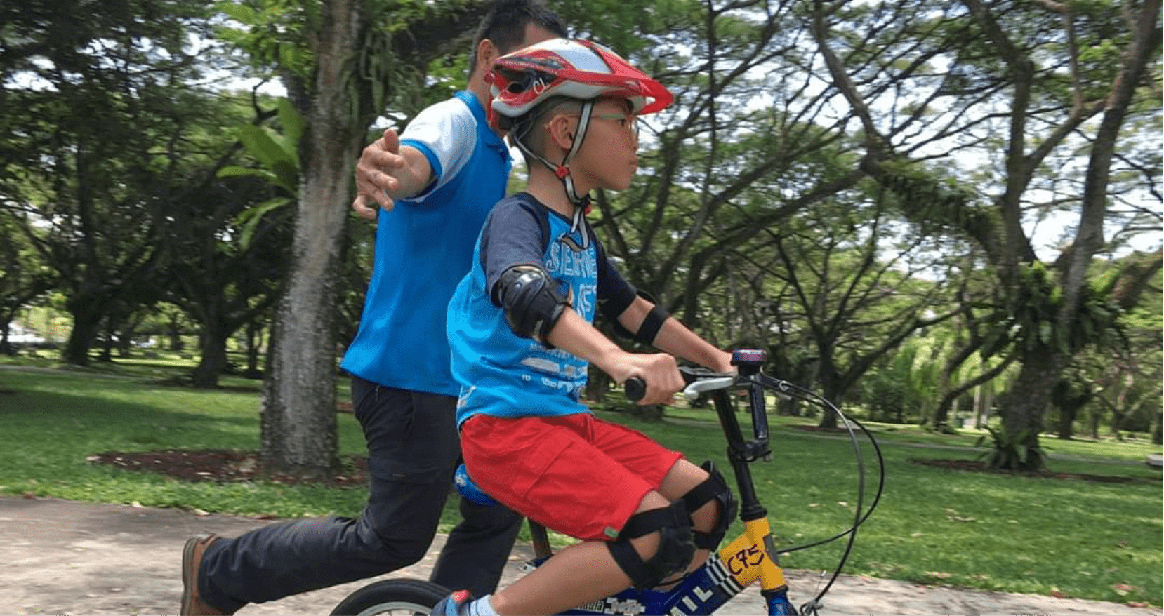 Cycling coach guiding a young student to ride a bike