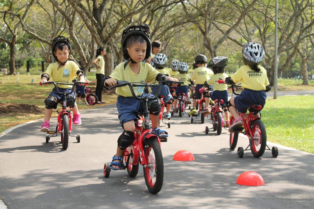 Group of little kids riding a kiddie bicycle