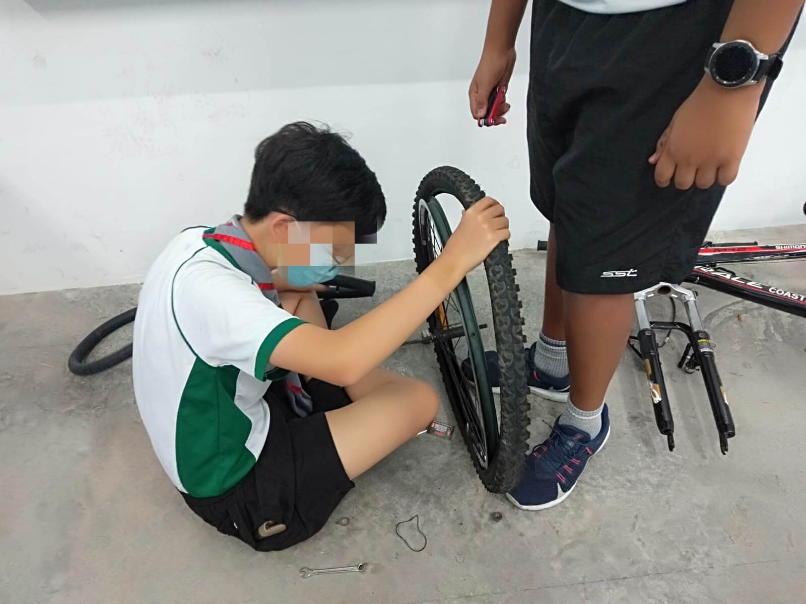 A male child fixing a bicyle flat tyre
