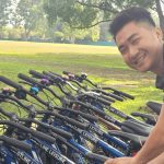 Person posing & smiling while picking out a bicycle