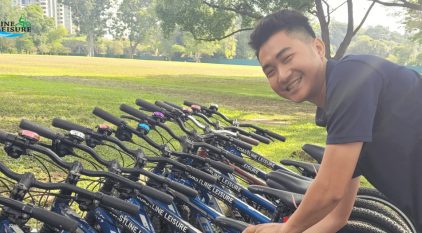 Person posing & smiling while picking out a bicycle