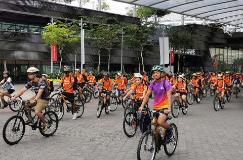 Group of cyclists wearing Orange Active sg t-shirts