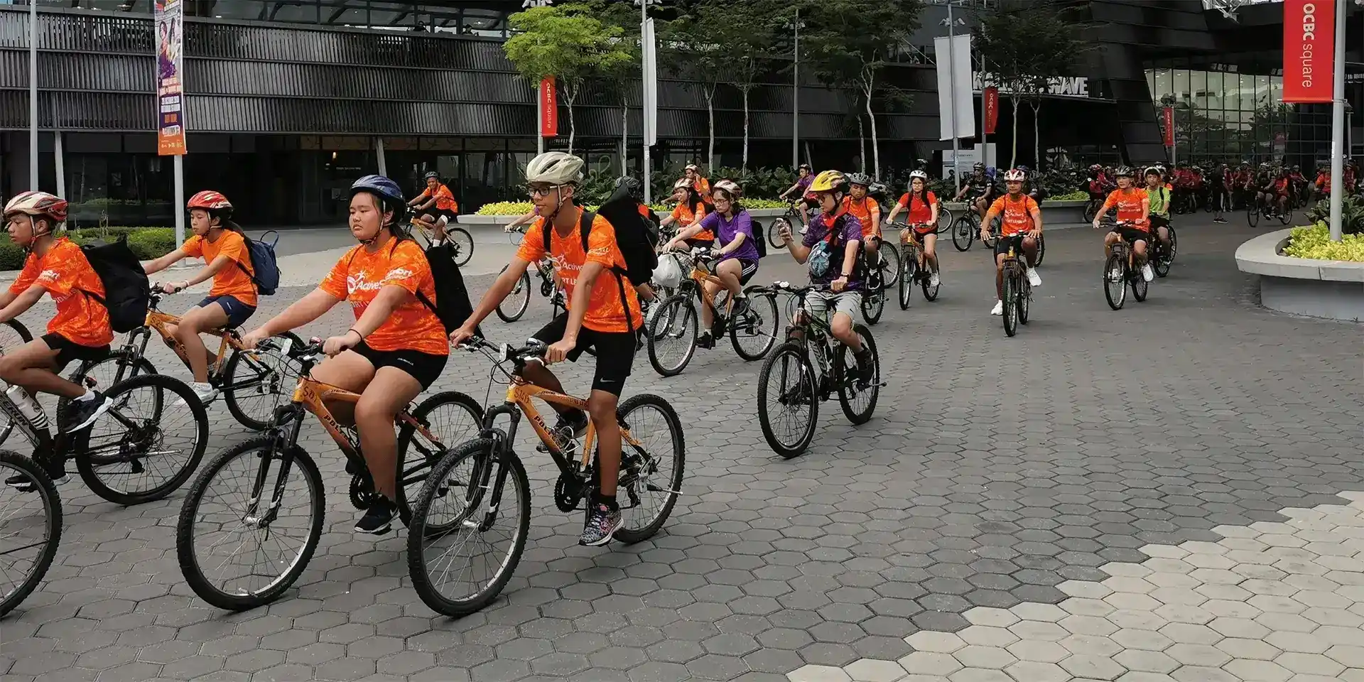 Group of cyclists wearing Orange Active sg t-shirts